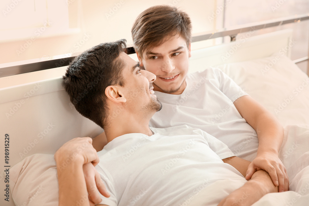 Young gay couple lying in bed at home Young gay couple lying in bed at home
