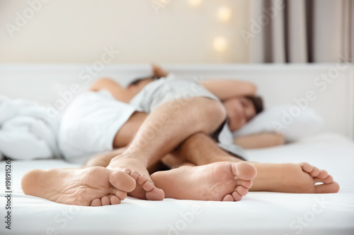 Bilde på lerret Young gay couple lying on bed at home