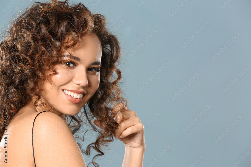 Beautiful young African American woman with long wavy hair on color background Beautiful young African American woman with long wavy hair on color background