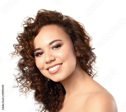 Beautiful young African American woman with long wavy hair on white background