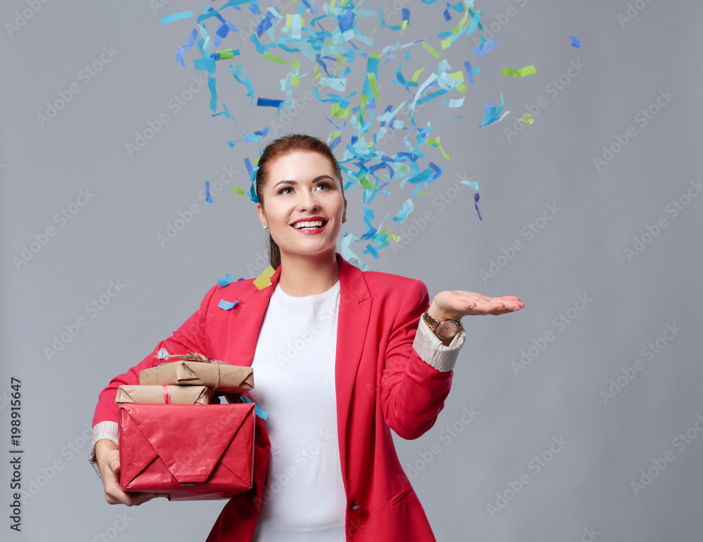 Beautiful happy woman with gift box at celebration party with confetti . Birthday or New Year eve celebrating concept Beautiful happy woman with gift box at celebration party with confetti . Birthday or New Year eve celebrating concept