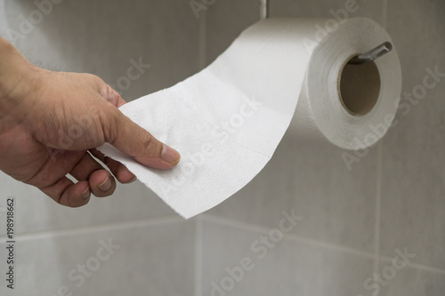 Hand picked toilet paper in the bathroom.