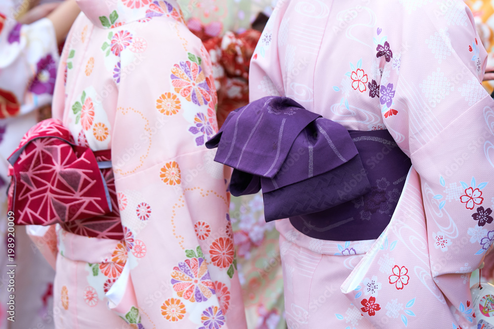 Young girl wearing Japanese kimono standing in front of Sensoji Temple in Tokyo, Japan. Kimono is a Japanese traditional garment. The word Young girl wearing Japanese kimono standing in front of Sensoji Temple in Tokyo, Japan. Kimono is a Japanese traditional garment. The word