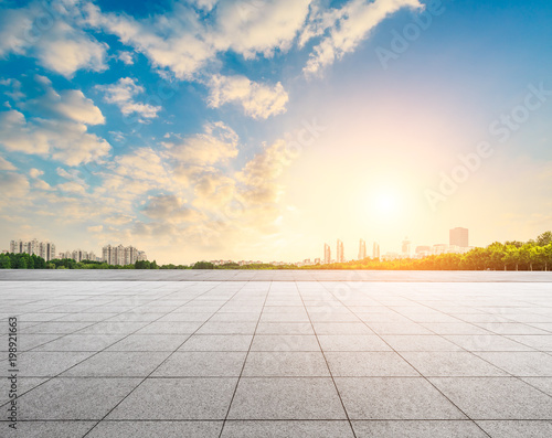empty square floor and modern city scenery at sunset