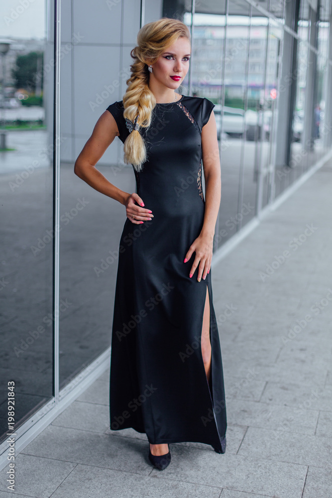Fototapeta premium Attractive lady in long evening dress on the street