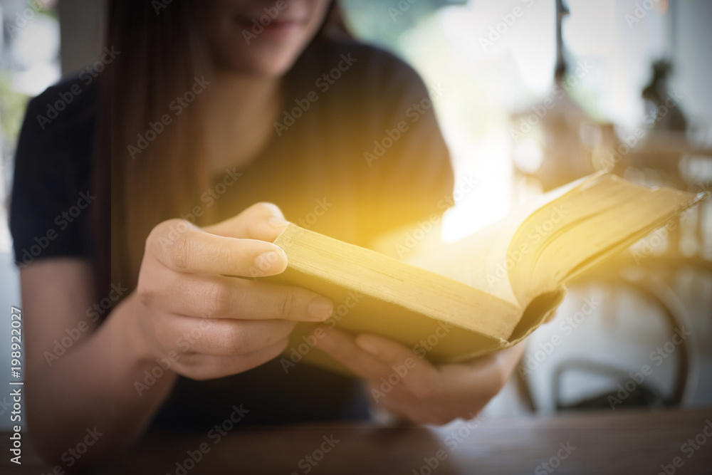 beautiful girl happy to sit reading a book Close-up of female relaxing in coffee shop cup of tea beautiful girl happy to sit reading a book Close-up of female relaxing in coffee shop cup of tea