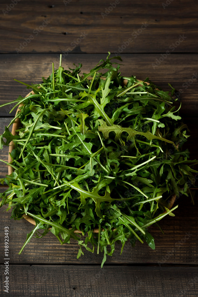 Fresh rucola with water droplets on a dark rustic background Fresh rucola with water droplets on a dark rustic background