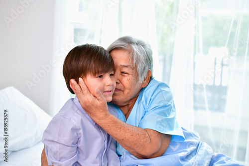 Patient Concept. Grandma's in the hospital. Waiting for someone to visit. Grandchildren visit grandma at the hospital. Grandma is happy to meet grandchildren. © S photographer