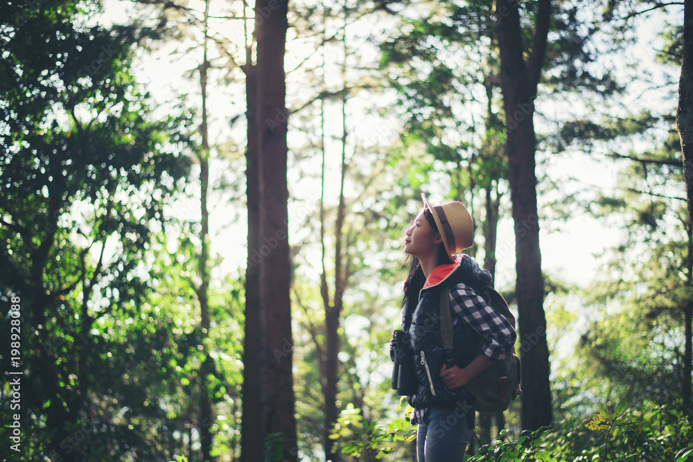 Woman with Binoculars walking in the forest