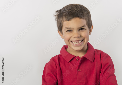 Adorable little boy with big smile and missing teeth, isolated on white background