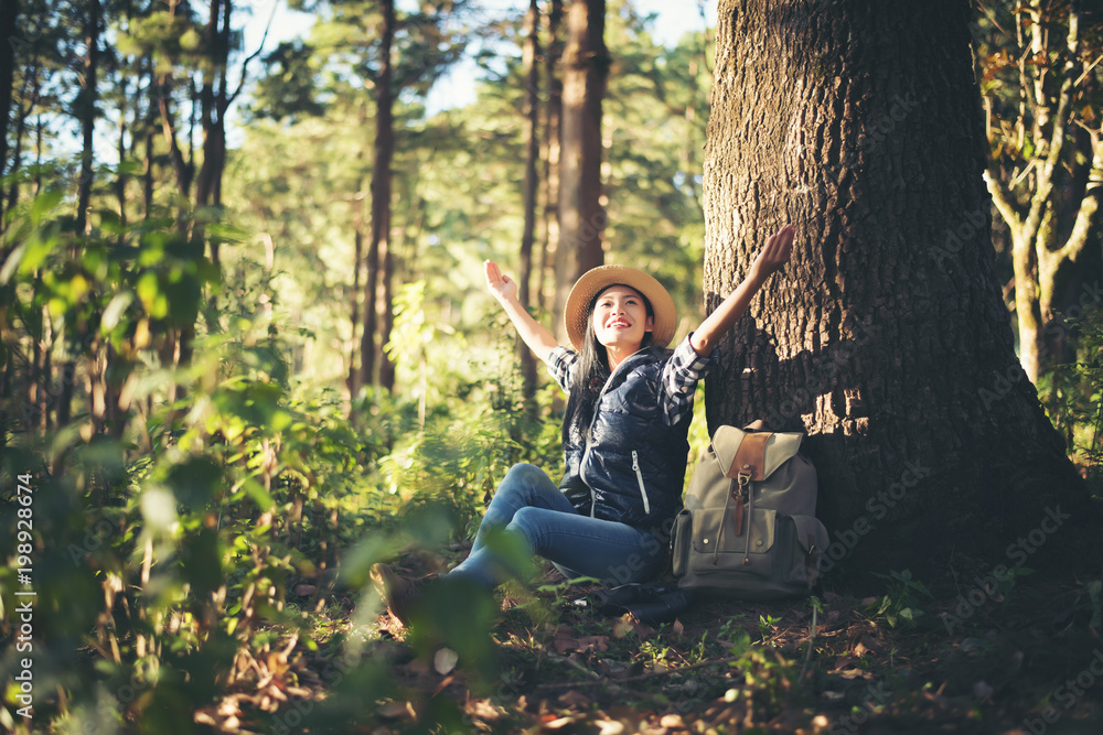Happy woman seated on the ground in the forest Happy woman seated on the ground in the forest