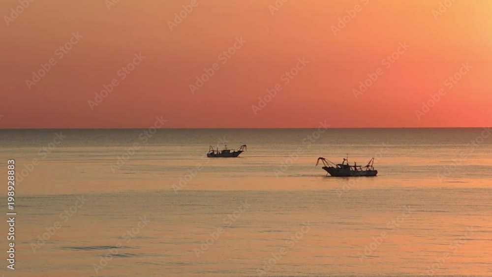 Fishing boats pull their nets at the sunrise. Adriatic cost. Emilia Romagna. Italy Fishing boats pull their nets at the sunrise. Adriatic cost. Emilia Romagna. Italy