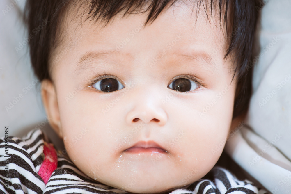 Portrait of cute asian baby girl looking at camera with dirty mouth after her meal Portrait of cute asian baby girl looking at camera with dirty mouth after her meal