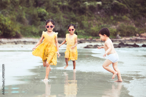 Happy asian children having fun to play and run on beach together in summer vacation in vintage color tone © pingpao