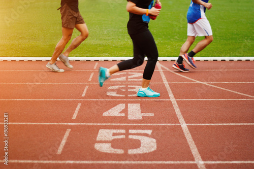 Running track number and athletics people running exercise on the track field outdoor