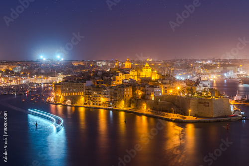 Illuminated skyline of Senglea and Three Cities from Grand Harbor in Malta photo