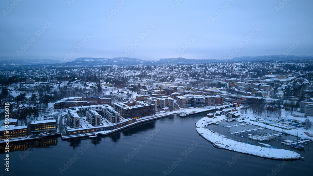 Winter Norwegian landscape of the fjord, boats and buildings around