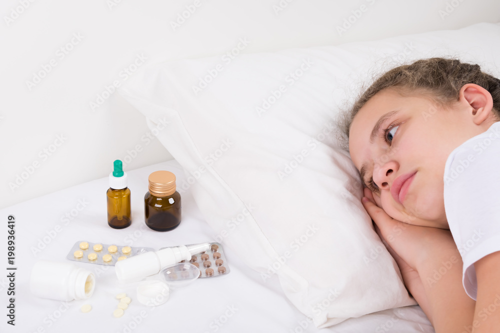 girl in bed looks at a lot of drugs and pills girl in bed looks at a lot of drugs and pills