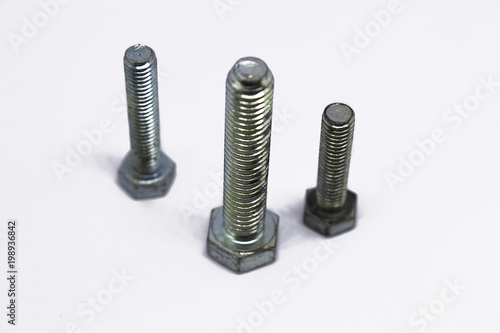 Three iron bolts of different sizes on a white background
