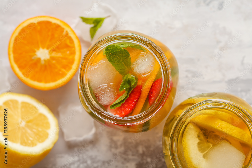 Fruit ice tea and ginger herbal ice tea with mint in a glass jars, white background, top view, copy space. Summer refreshing drink concept. Fruit ice tea and ginger herbal ice tea with mint in a glass jars, white background, top view, copy space. Summer refreshing drink concept.