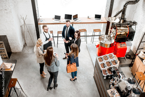Canvas Print Business people talking and having fun durnig a coffee time in the modern cafe interior