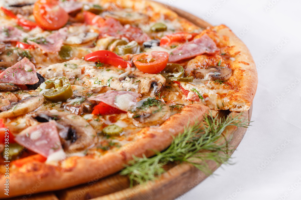 Italian kitchen and cooking concept. Hot tasty sliced with ham, sausage, jalapenos, mushrooms, tomato. Eat delivery concept. Italian kitchen and cooking concept. Hot tasty sliced with ham, sausage, jalapenos, mushrooms, tomato. Eat delivery concept.