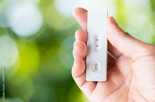 hcg test in hand with nature  background