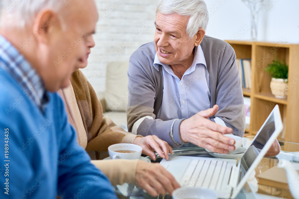Portrait modern senior people using laptop in retirement home and smiling happily, copy space Portrait modern senior people using laptop in retirement home and smiling happily, copy space