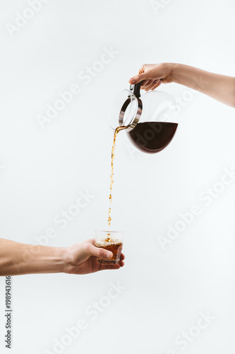 Fotografie cropped view of hands with coffee pot and glass, isolated on white