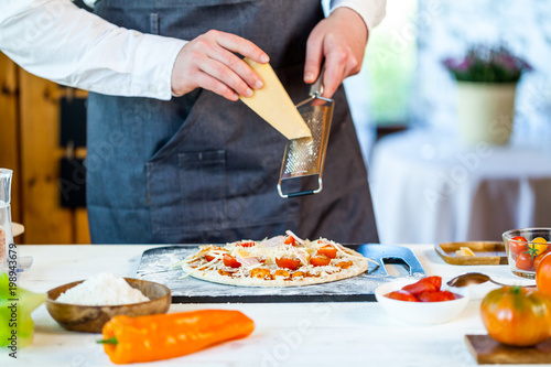 closeup hands of chef making fresh homemade traditional italian pizza. wallpaper for pizzeria and cooking food concept