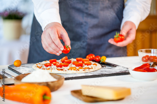 closeup hands of chef making fresh homemade traditional italian pizza. wallpaper for pizzeria and cooking food concept