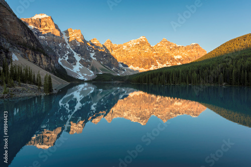 Moraine Lake  Canada. Beautiful sunrise under the Moraine lake with snow-covered peaks above it in Canadian Rockies   Banff National Park.