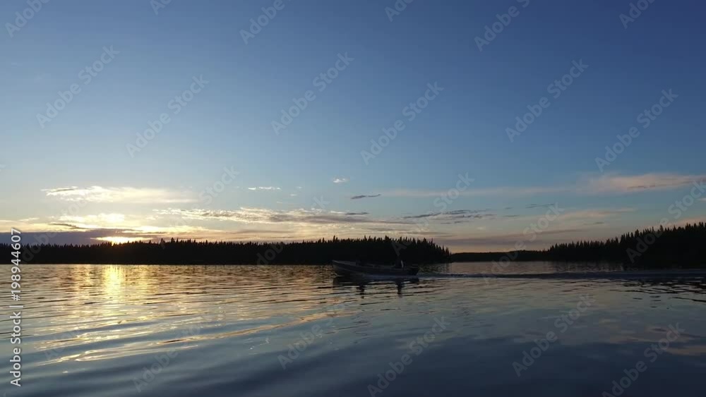 Boat sailing on lake at sunset Boat sailing on lake at sunset