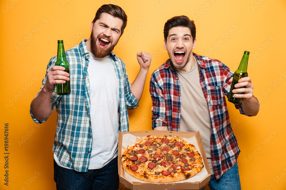 Portrait of a two happy young men drinking beer