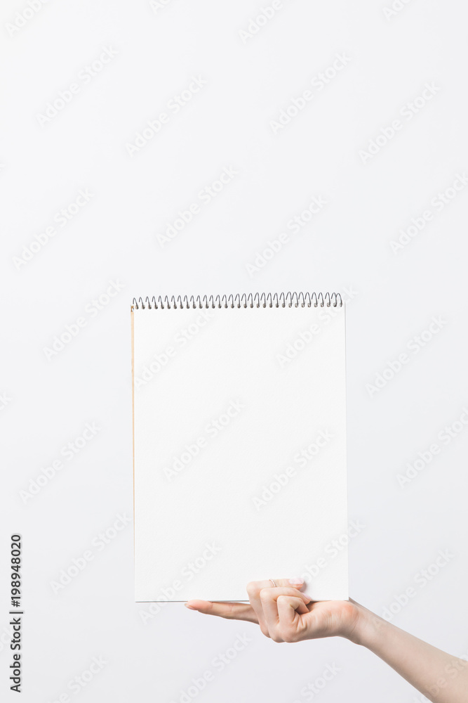 partial view of woman holding blank sketchbook in hand isolated on white partial view of woman holding blank sketchbook in hand isolated on white