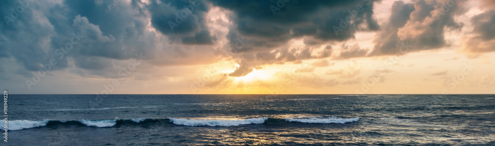 Fototapeta premium Fantastic stunning colorful sunset by the sea, waves and sunlight
