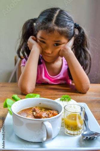 фотографія Asian kid getting bored of food refusing meal with appetite loss, no hungry eati