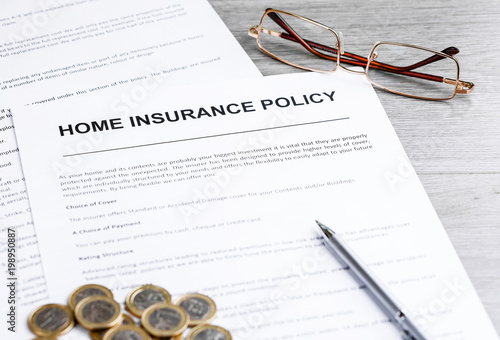 Home insurance policy. Glasses, pen and home insurance policy. Business background concept. Mortgage loading real estate property with house and money concept