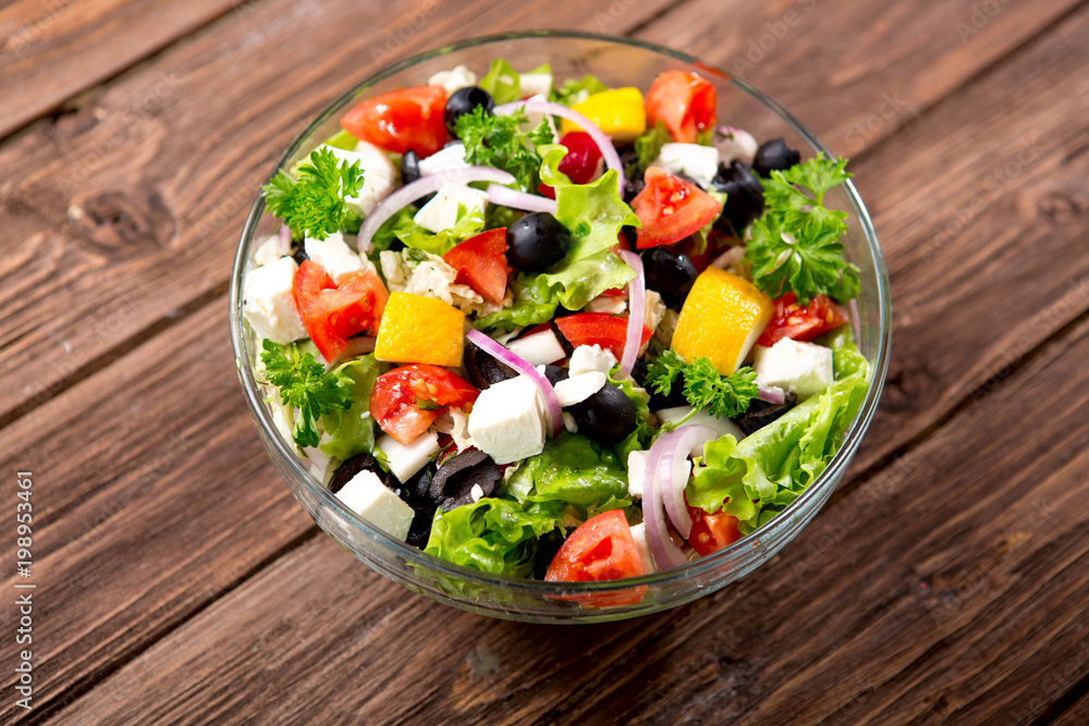 Fresh vegetable salad in bowl with fresh lettuce, tomatoes and cucumber. Top view Fresh vegetable salad in bowl with fresh lettuce, tomatoes and cucumber. Top view