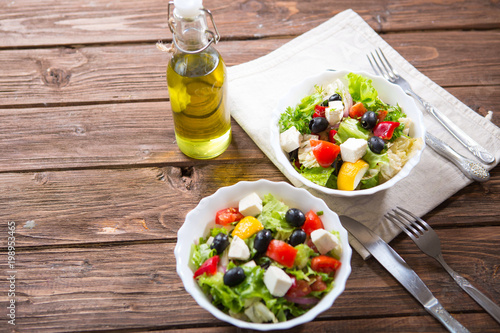 Fresh vegetable salad with feta cheese, fresh lettuce, cherry tomatoes, red onion and pepper photo