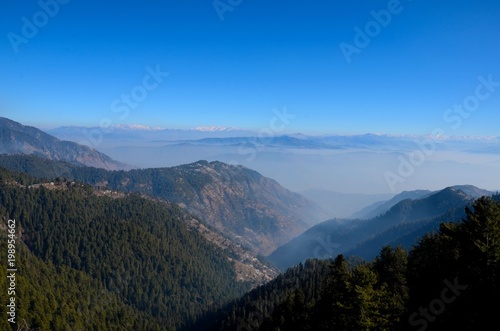 Murree / Nathia Gali, Pakistan - January 12, 2018: A distant view of Himalayan mountain range between the Pakistani towns of Murree and Nathia Gali. Both towns are popular tourist spots. 
