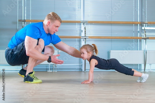 Group of children doing kids gymnastics in gym with teacher. Happy sporty children in gym. bar exercise. plank.