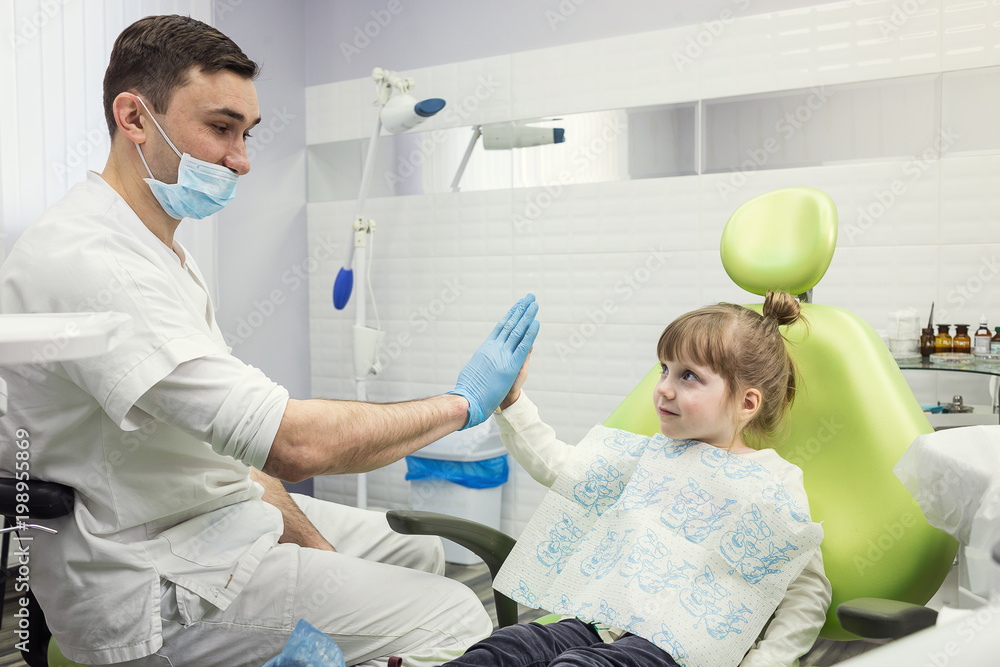 Fototapeta premium Dentist examining little girl's teeth in clinic. Dental problem.