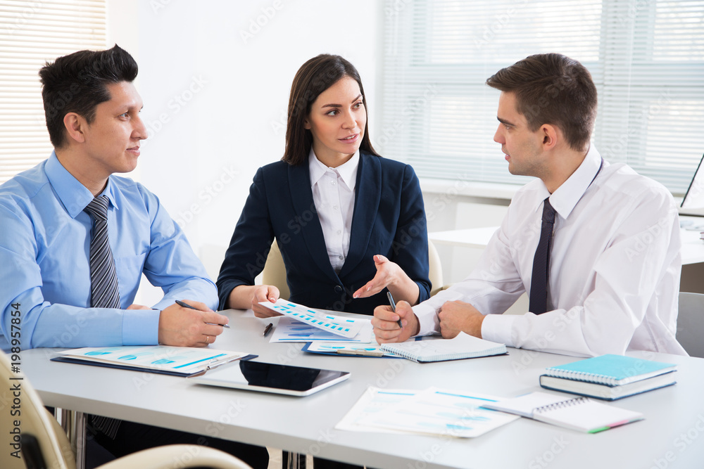 Businesswoman explains to businessmen a new project Businesswoman explains to businessmen a new project