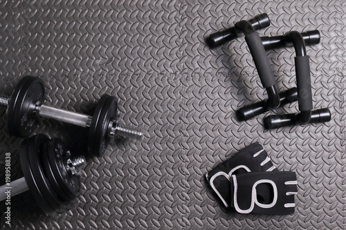 Accessories for fitness at home, mat, dumbbells of varying weights, gloves for sports. the concept of sport, fitness and a healthy lifestyle.
