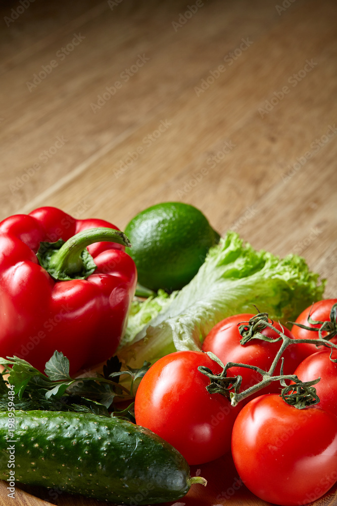 Artistic still life of assorted fresh vegetables and herbs on rustic wooden background, top view, selective focus.