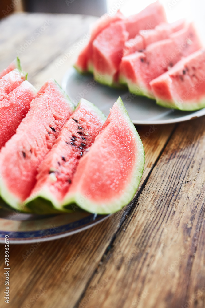 sliced slices of ripe juicy watermelon lie on a plate on a wooden table. small depth of field.