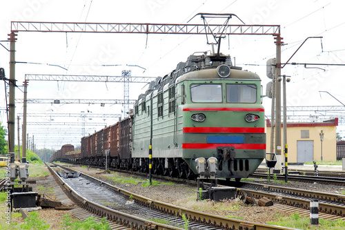 Electric locomotive of green color pulls freight cars