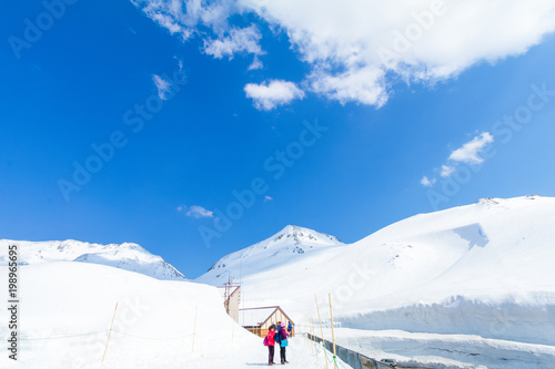 TOYAMA , JAPAN - April 30, 2017:People are walking at Tateyama Kurobe Alpine Route , the road between the snow mountains wall with blue sky background in Toyama Prefecture, Japan.