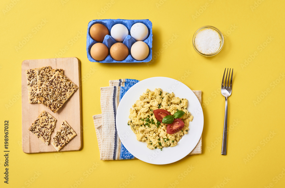 Scrambled eggs in plate on rustic background